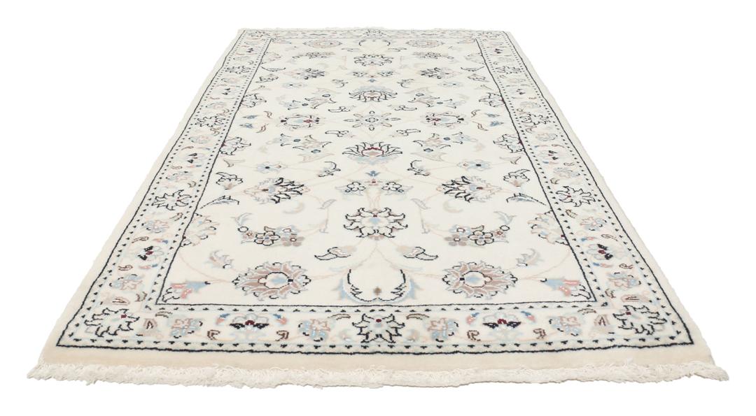 Een rechthoekig handgeknoopt Nain 9La tapijt met een beige veld en florale motieven uit het Midden-Oosten.