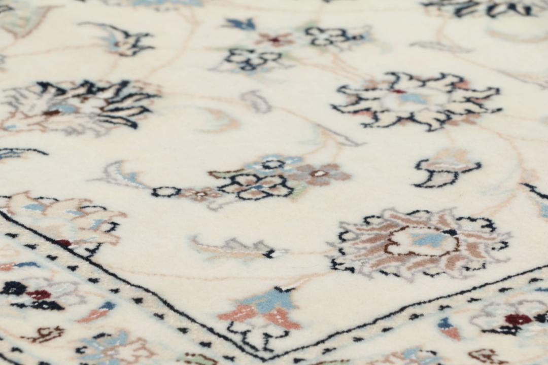 Een rechthoekig handgeknoopt Nain 9La tapijt met een beige veld en florale motieven uit het Midden-Oosten.