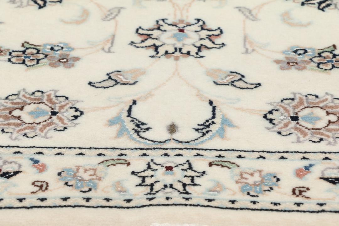Een rechthoekig handgeknoopt Nain 9La tapijt met een beige veld en florale motieven uit het Midden-Oosten.