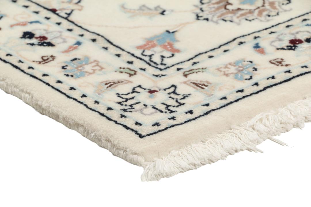 Een rechthoekig handgeknoopt Nain 9La tapijt met een beige veld en florale motieven uit het Midden-Oosten.
