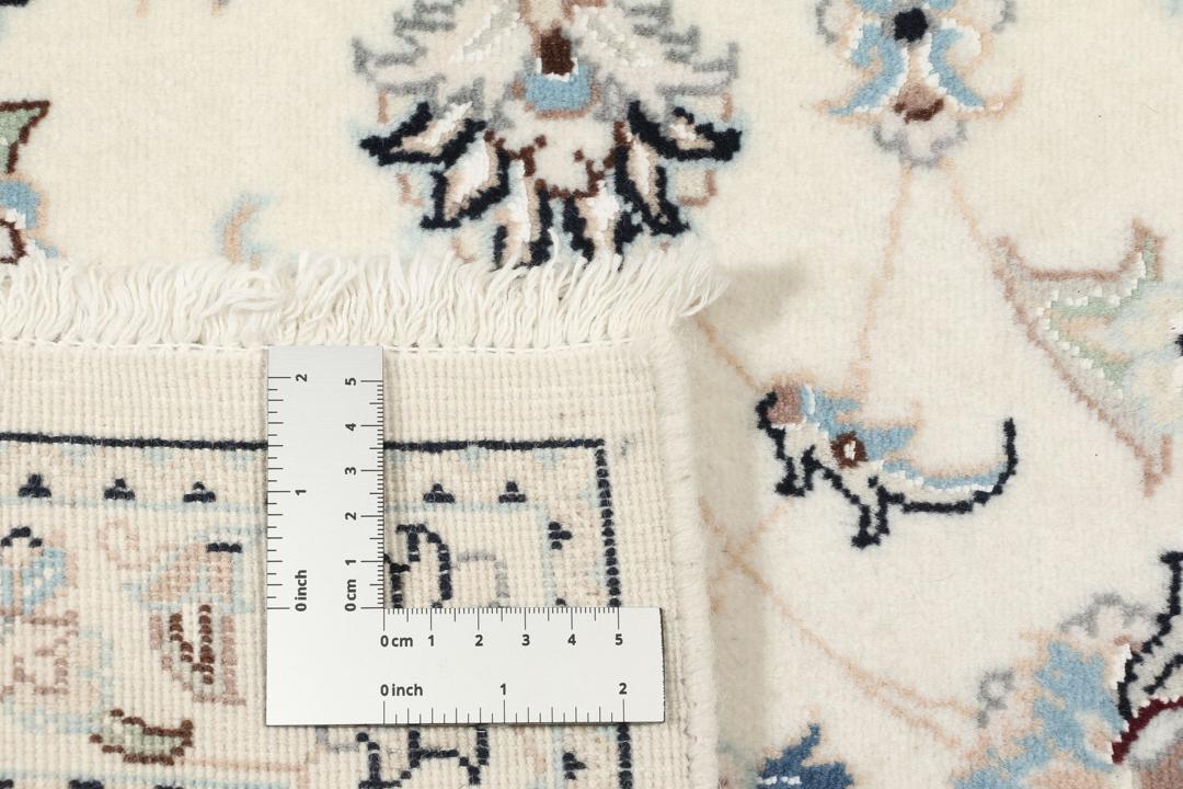 Een rechthoekig handgeknoopt Nain 9La tapijt met een beige veld en florale motieven uit het Midden-Oosten.