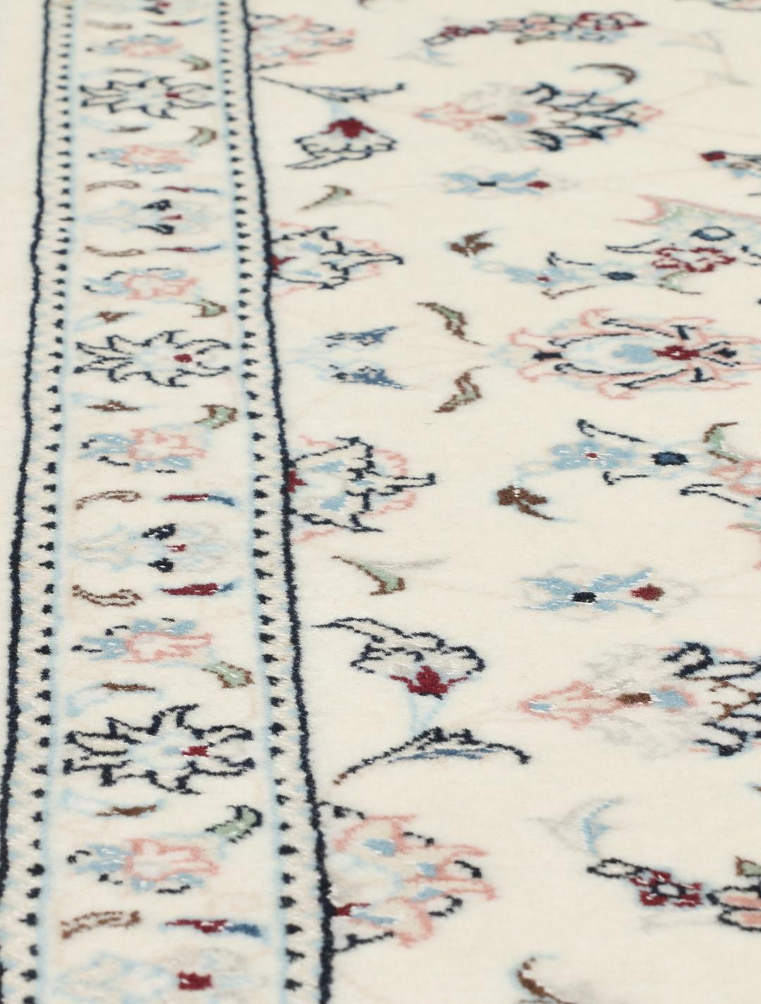 A rectangular Nain 9La rug from the Middle East with a beige background and floral motifs