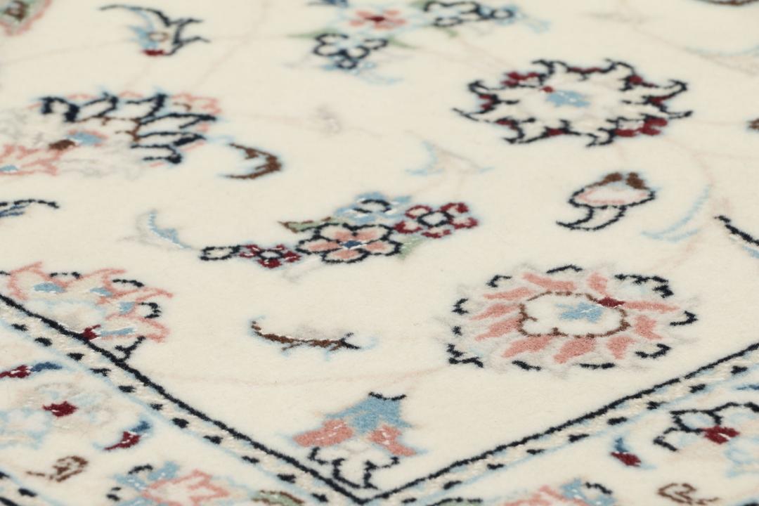 A rectangular Nain 9La rug from the Middle East with a beige background and floral motifs