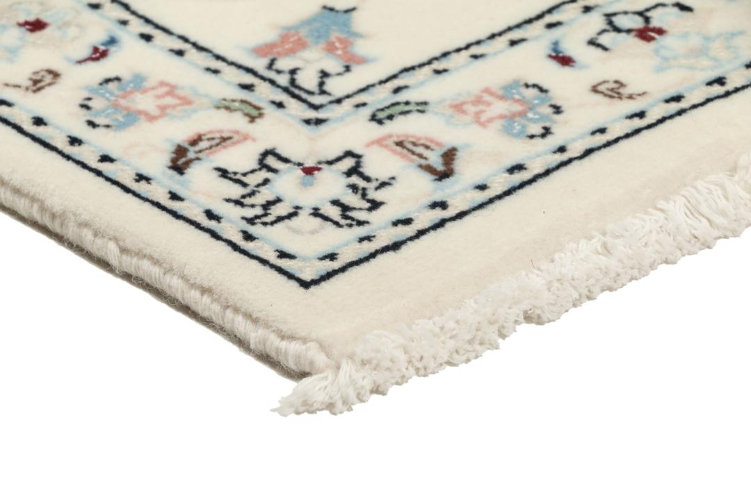 A rectangular Nain 9La rug from the Middle East with a beige background and floral motifs