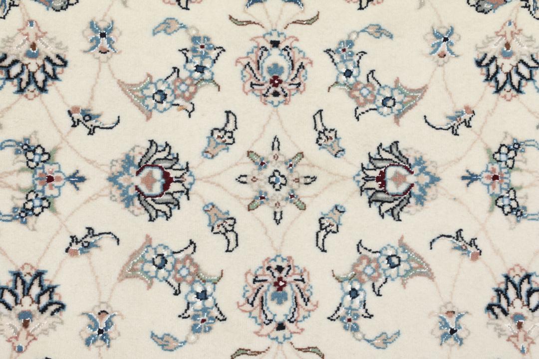 Een rechthoekig handgeknoopt Nain 9La tapijt uit het Midden-Oosten met een beige achtergrond en bloempatronen in blauw en roze.