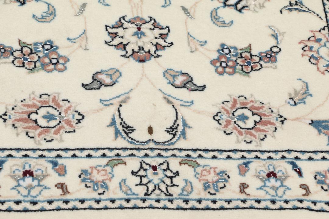 Een rechthoekig handgeknoopt Nain 9La tapijt uit het Midden-Oosten met een beige achtergrond en bloempatronen in blauw en roze.