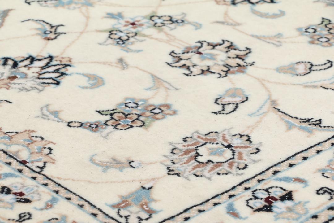 Handgeknoopt Nain 9La tapijt met delicate bloemmotieven op een beige achtergrond