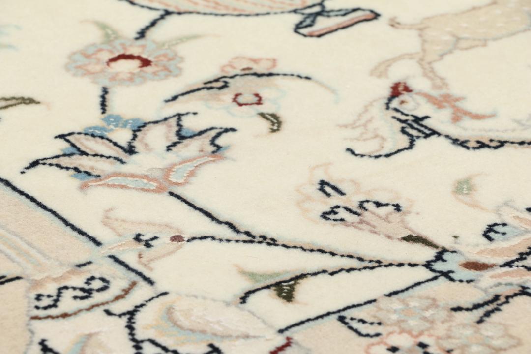Et rektangulært håndknyttet Nain 9La-tæppe med delikate blomstermotiver i beige og blå nuancer.