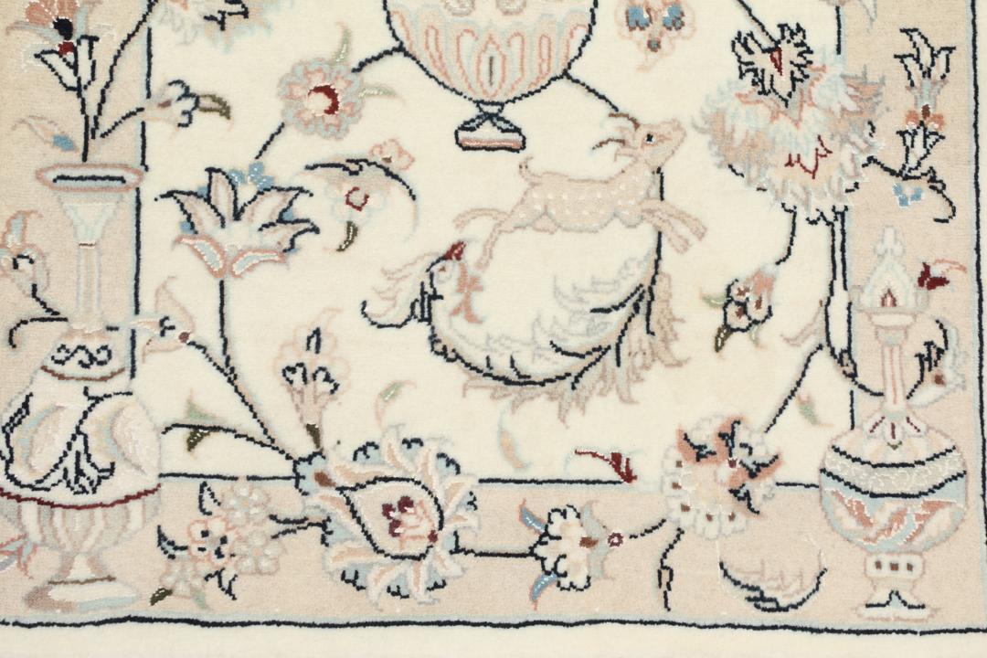 Et rektangulært håndknyttet Nain 9La-tæppe med delikate blomstermotiver i beige og blå nuancer.
