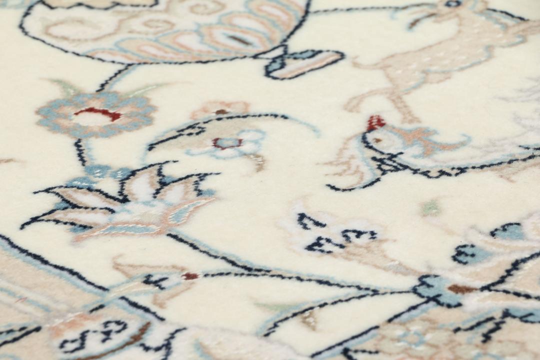Een handgeknoopte Nain 9La loper met bloem- en diermotieven in beige en blauwe tinten.