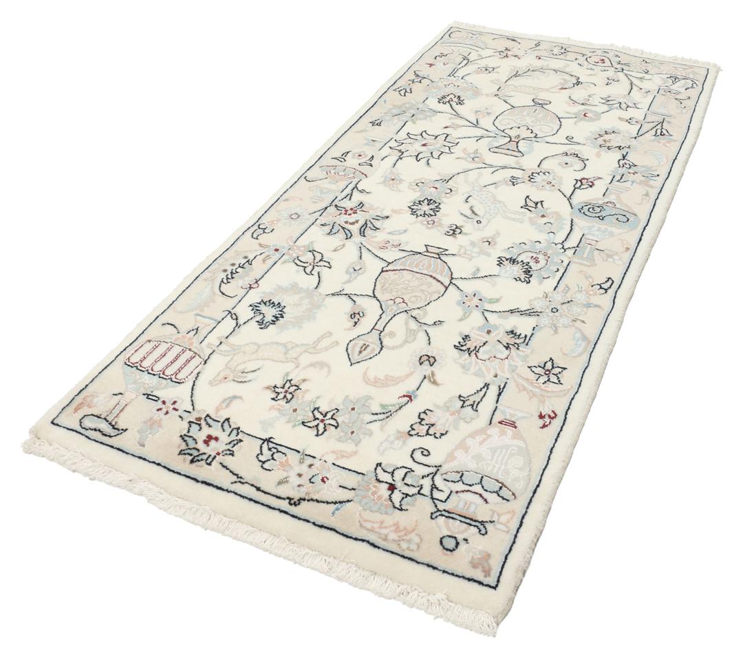 Et håndknyttet Nain 9La tæppe fra Mellemøsten i en blød beige farve med blomstermotiver.