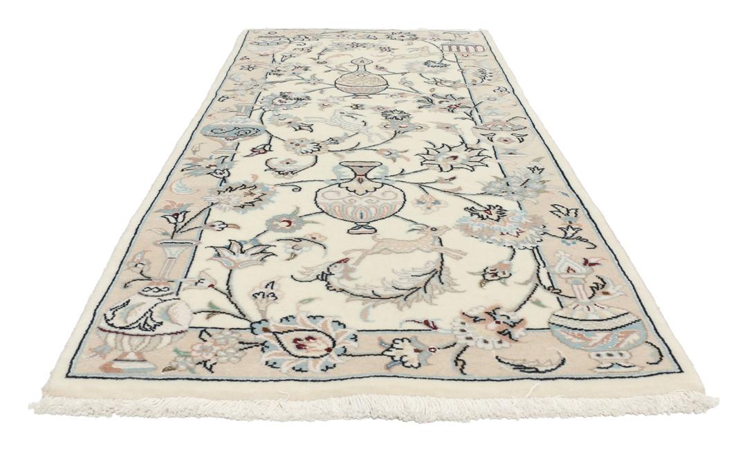 Et håndknyttet Nain 9La tæppe fra Mellemøsten i en blød beige farve med blomstermotiver.