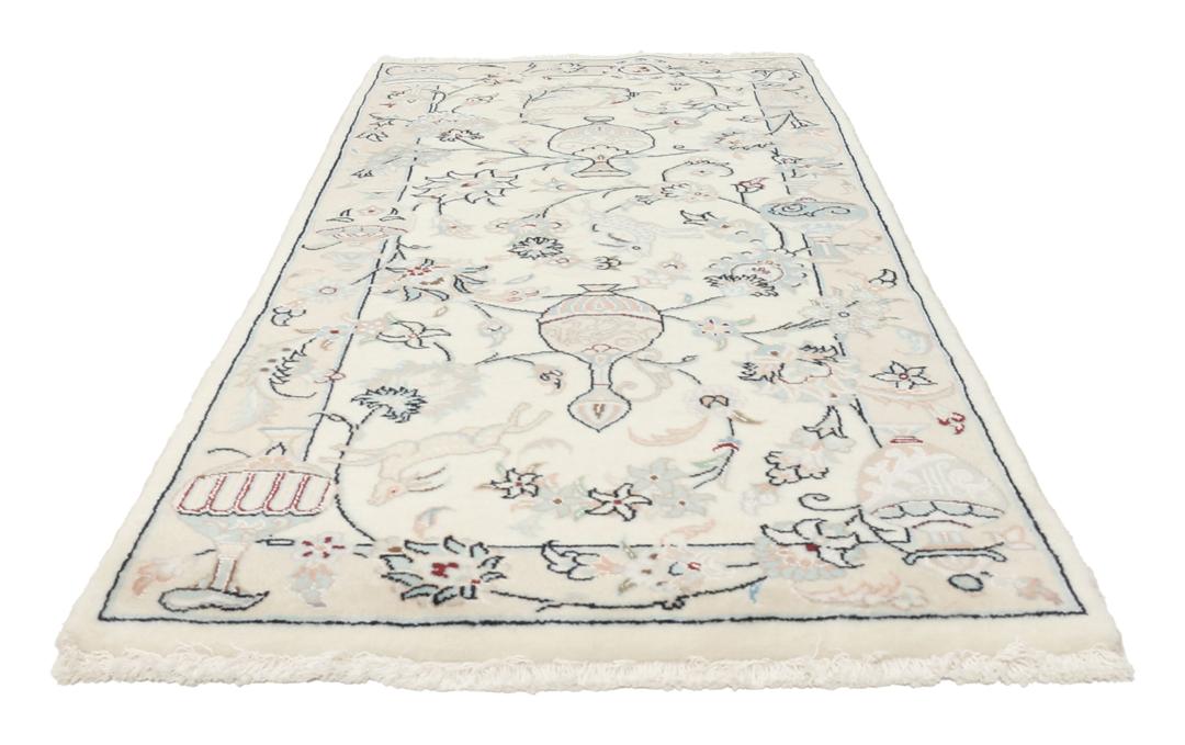 Et håndknyttet Nain 9La tæppe fra Mellemøsten i en blød beige farve med blomstermotiver.