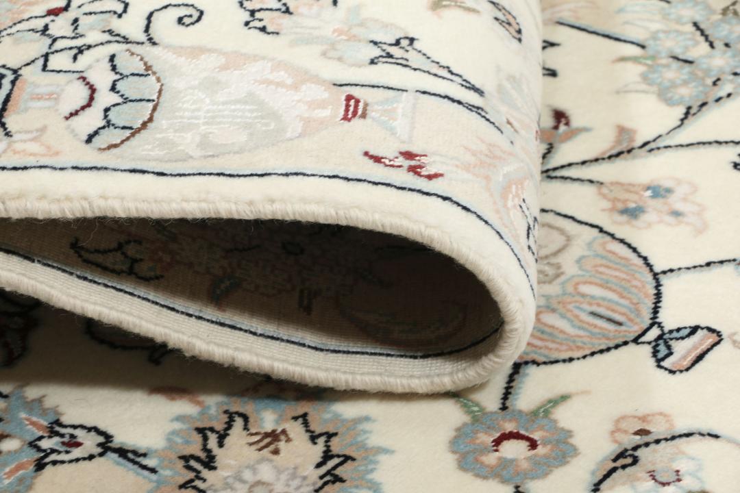 Et håndknyttet Nain 9La tæppe fra Mellemøsten i en blød beige farve med blomstermotiver.
