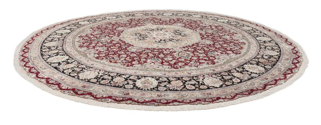 Een rond, handgeknoopt Tabriz-tapijt uit het Midden-Oosten met een levendig rood en zwart bloemendesign.