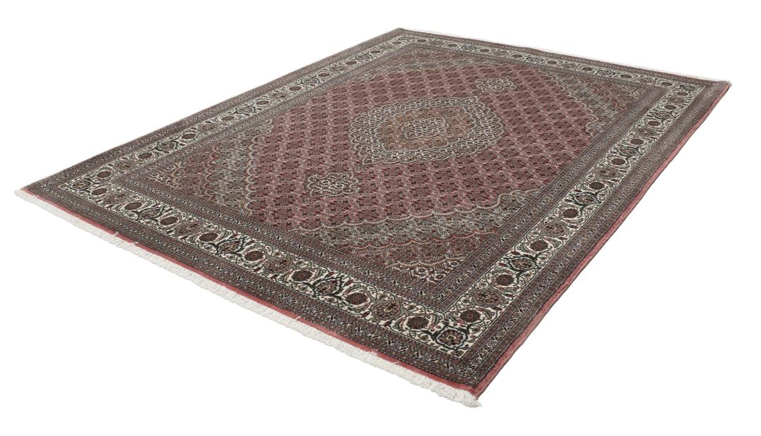 Et rektangulært håndknyttet Tabriz-tæppe fra Mellemøsten i mørkerøde og mørkeblå toner.