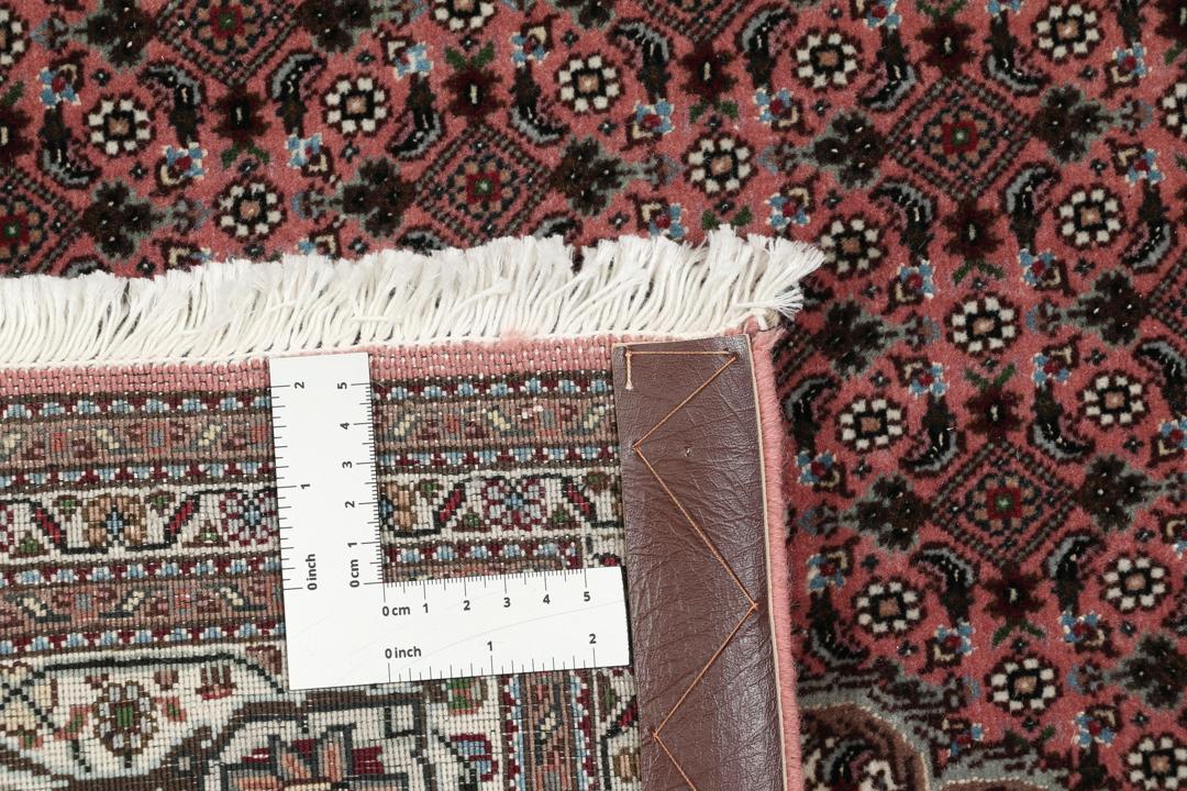 Et rektangulært håndknyttet Tabriz-tæppe fra Mellemøsten i mørkerøde og mørkeblå toner.