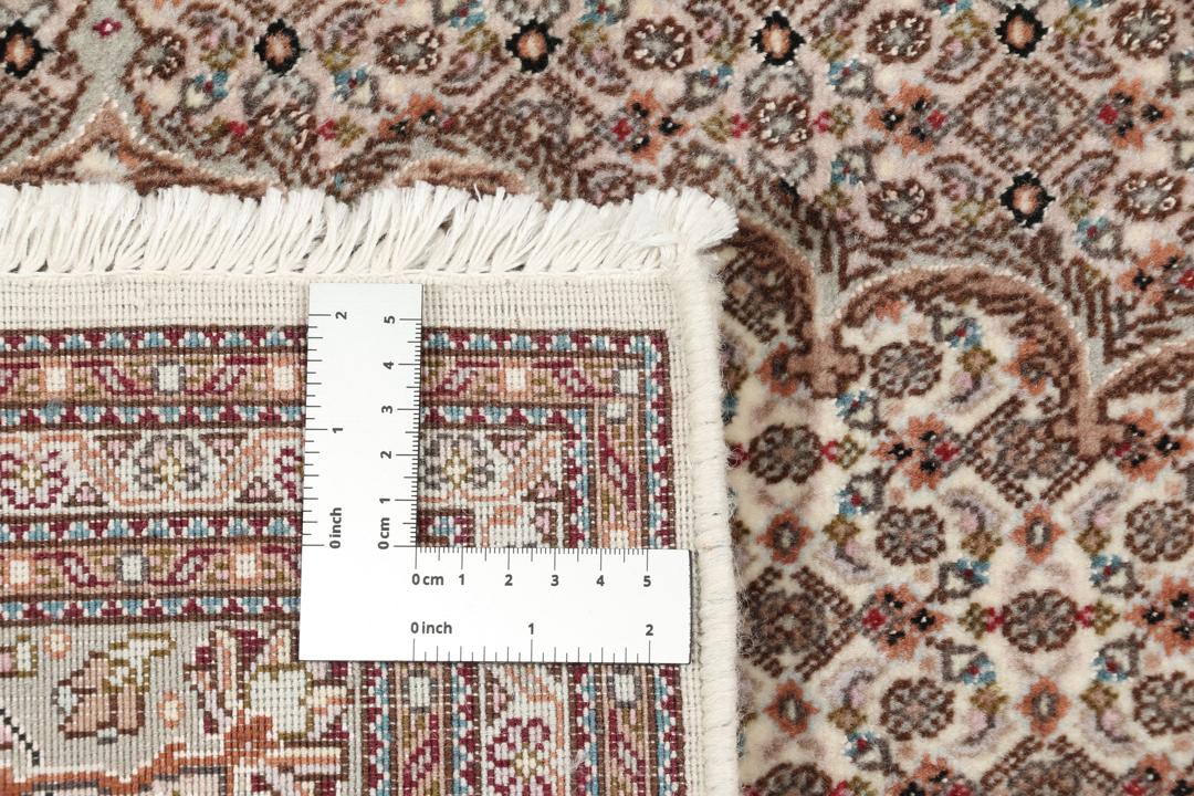 Håndknyttet Tabriz tæppe med en central medaljon og blomstermønstre i røde og beige nuancer