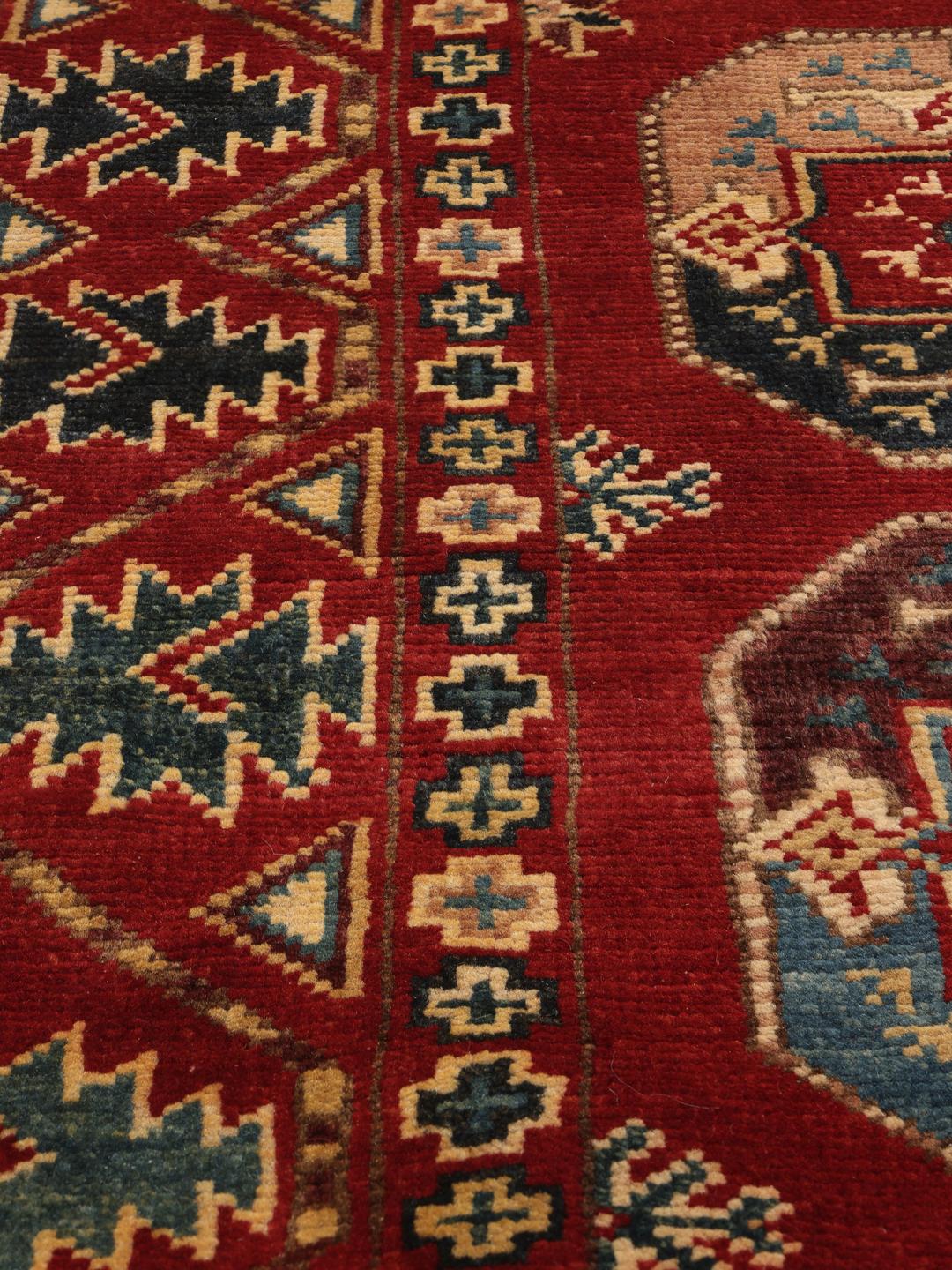 Covor Kazak înnodat manual din Afganistan cu fundal roșu și motive geometrice