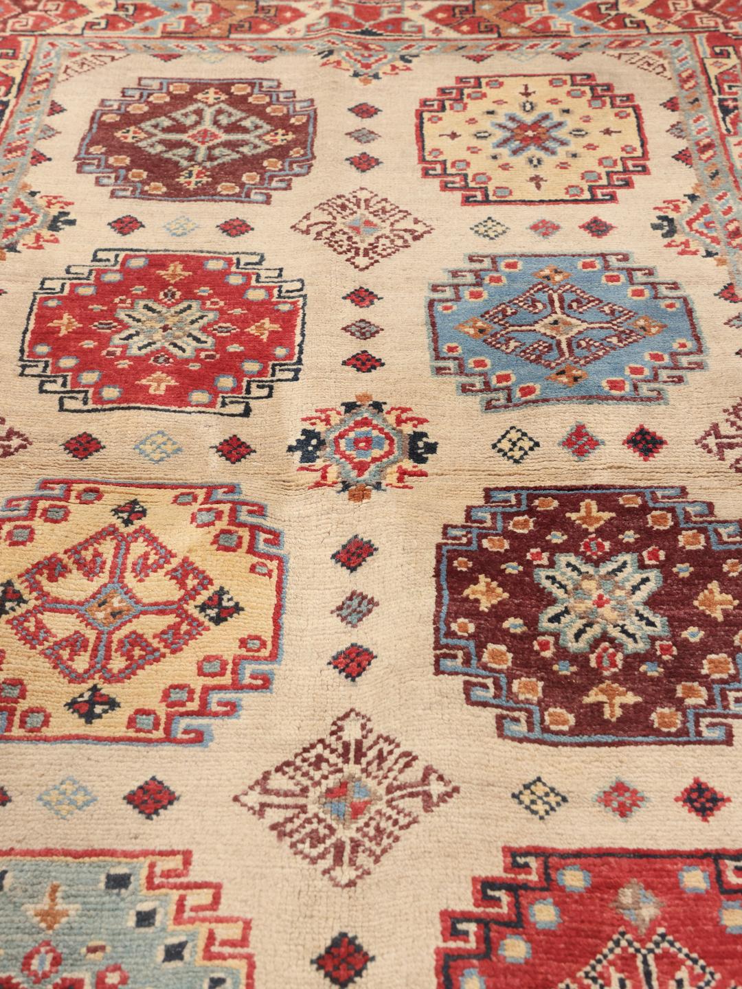 Handgeknoopt Kazak-tapijt uit Afghanistan met levendige geometrische patronen in veelkleurige wol.