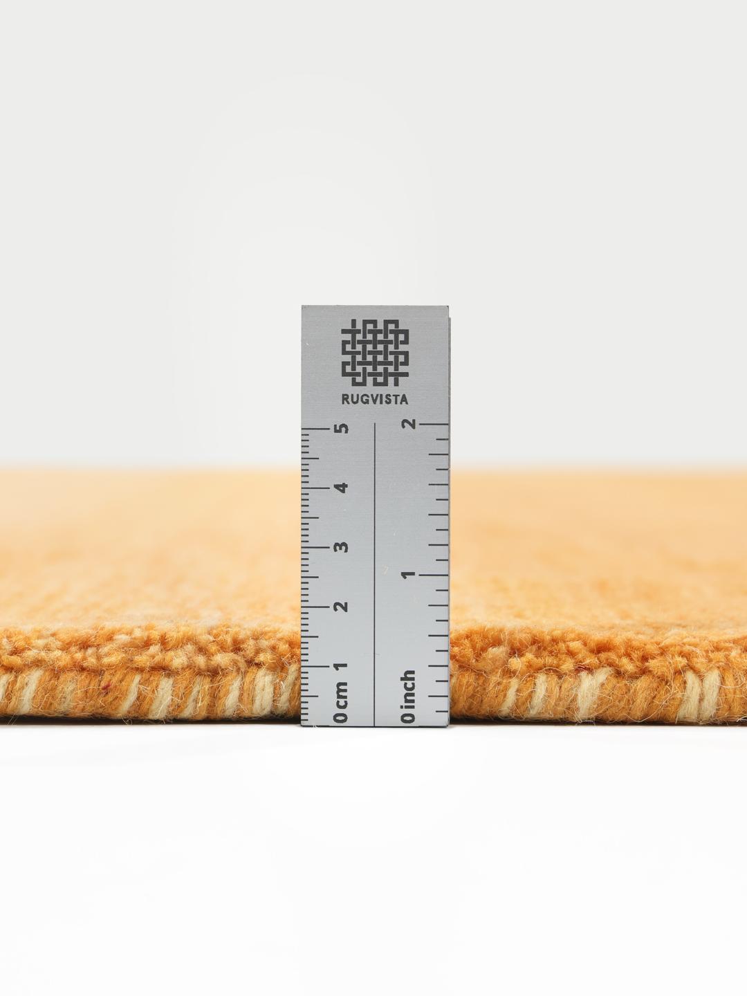 Een rechthoekig handgeweven vloerkleed in verschillende tinten oranje.