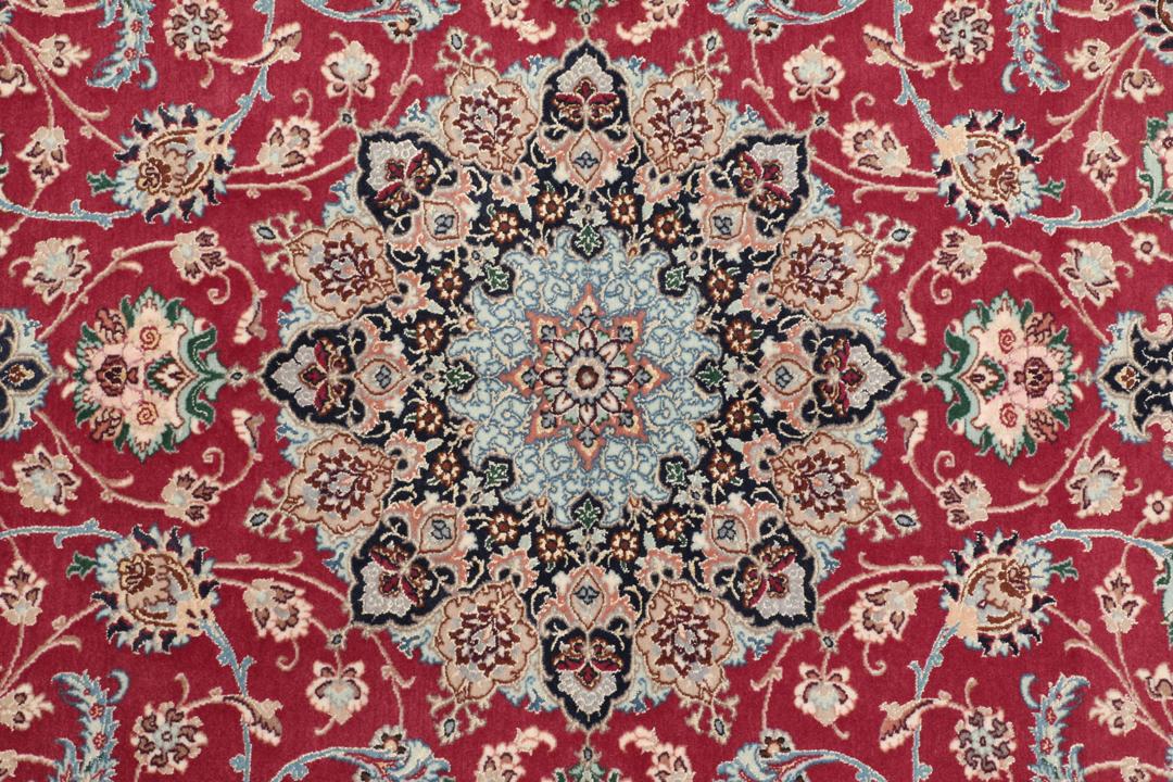 Håndknyttet Isfahan-tæppe med rød bund og indviklede blå og beige blomstermønstre.