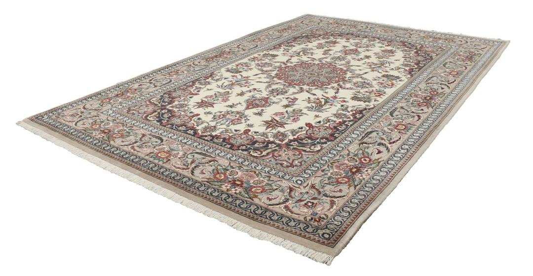 Een rechthoekig Isfahan-tapijt uit het Midden-Oosten met een centraal medaillon en bloemmotieven in beige, rode en blauwe tinten.