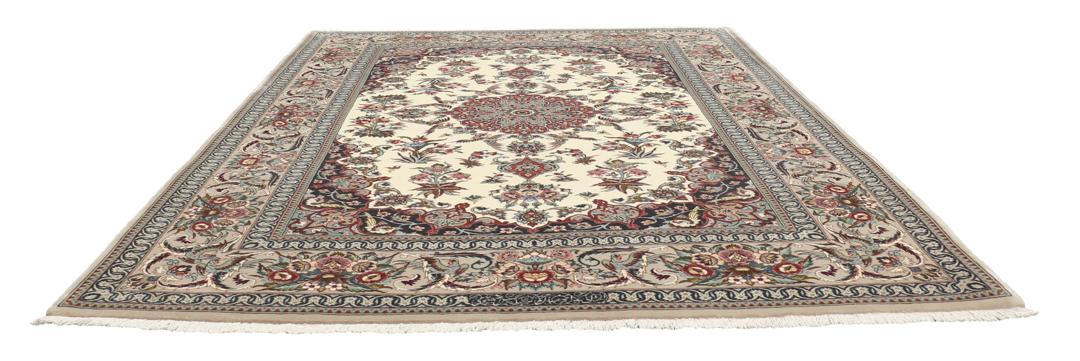 Een rechthoekig Isfahan-tapijt uit het Midden-Oosten met een centraal medaillon en bloemmotieven in beige, rode en blauwe tinten.