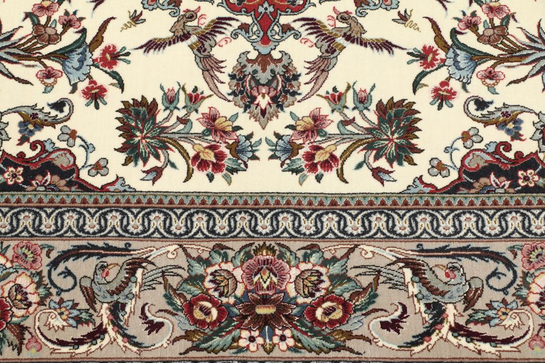 Een rechthoekig Isfahan-tapijt uit het Midden-Oosten met een centraal medaillon en bloemmotieven in beige, rode en blauwe tinten.