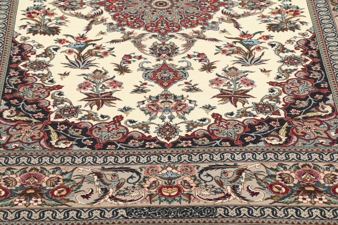 Een rechthoekig Isfahan-tapijt uit het Midden-Oosten met een centraal medaillon en bloemmotieven in beige, rode en blauwe tinten.