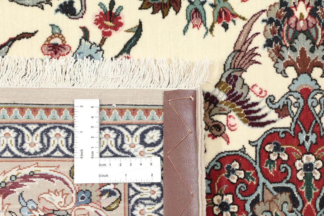 Een rechthoekig Isfahan-tapijt uit het Midden-Oosten met een centraal medaillon en bloemmotieven in beige, rode en blauwe tinten.