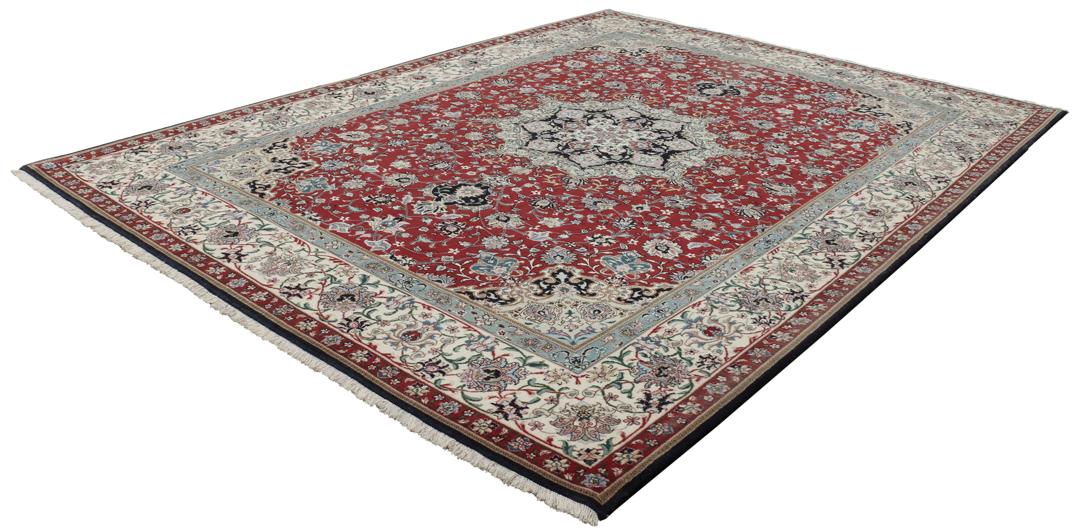 Een handgeknoopt Tabriz-tapijt met een rood veld en een ingewikkeld bloemmedaillon uit het Midden-Oosten.