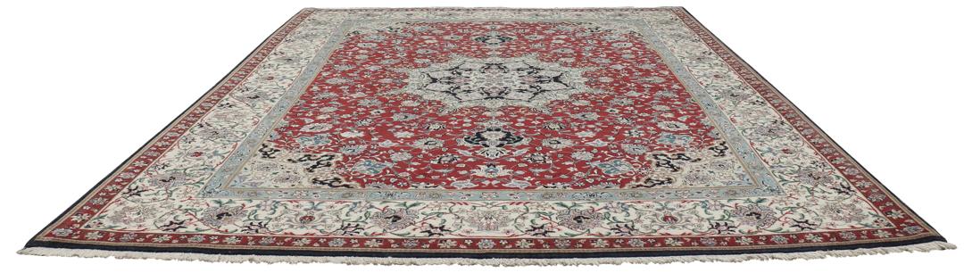 Een handgeknoopt Tabriz-tapijt met een rood veld en een ingewikkeld bloemmedaillon uit het Midden-Oosten.
