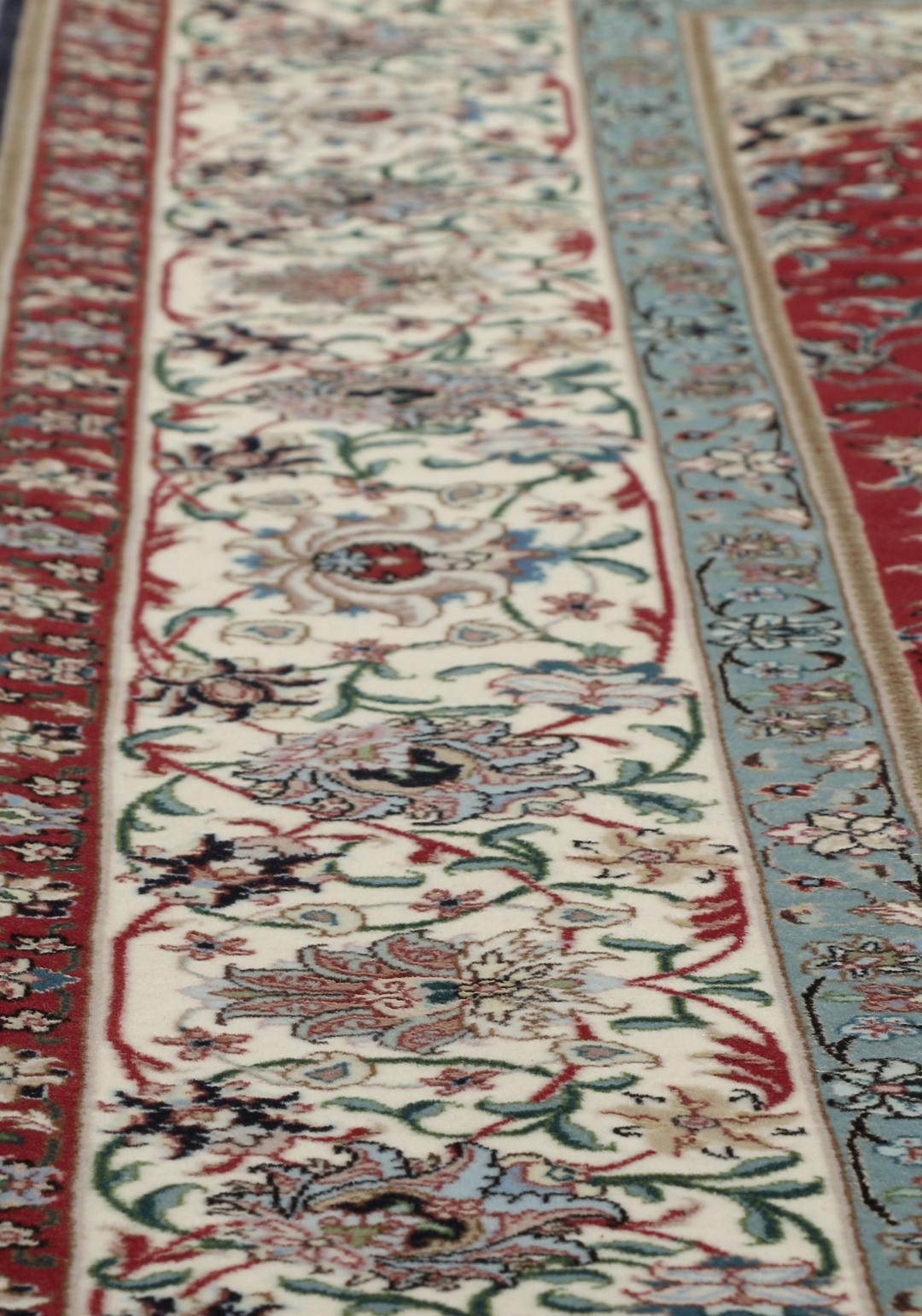 Een handgeknoopt Tabriz-tapijt met een rood veld en een ingewikkeld bloemmedaillon uit het Midden-Oosten.