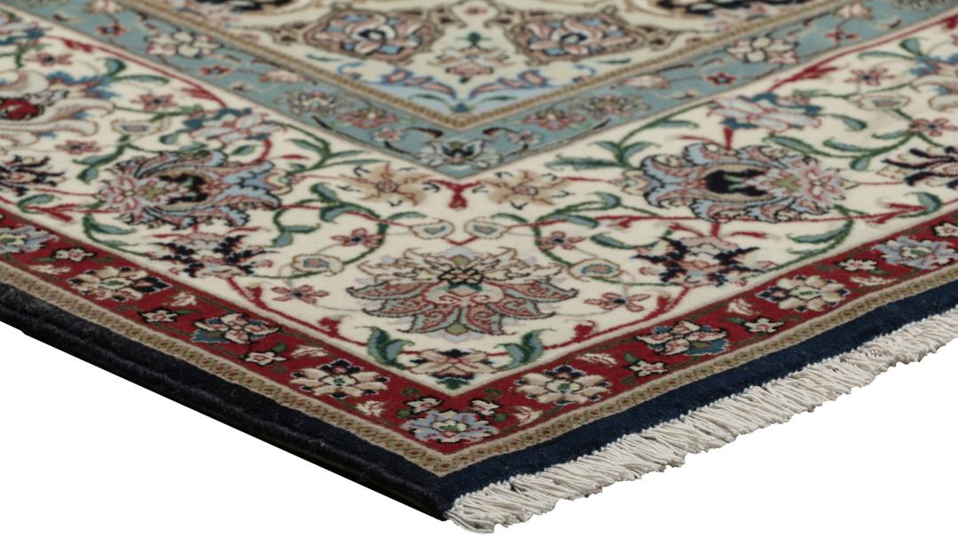 Een handgeknoopt Tabriz-tapijt met een rood veld en een ingewikkeld bloemmedaillon uit het Midden-Oosten.
