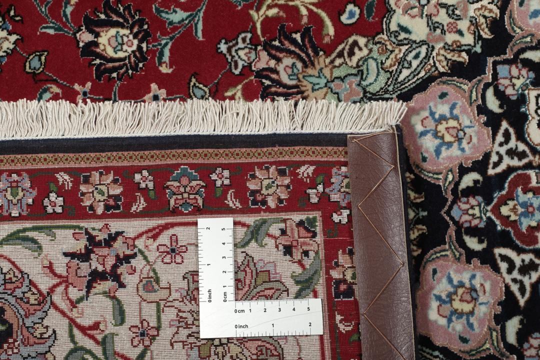 Een handgeknoopt Tabriz-tapijt met een rood veld en een ingewikkeld bloemmedaillon uit het Midden-Oosten.
