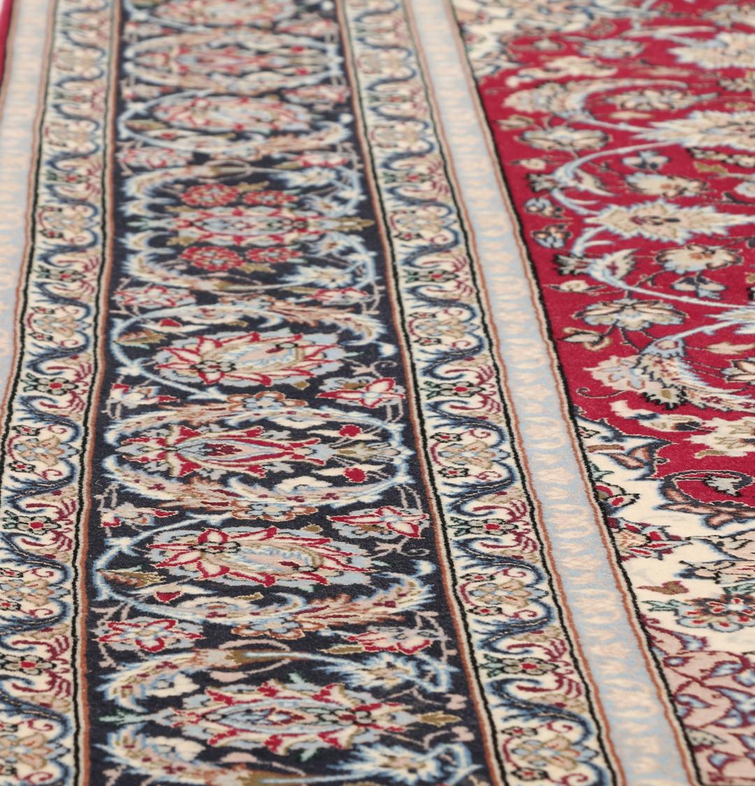 Handgeknoopt Isfahan-tapijt met een rood veld en verfijnd bloemmedaillon