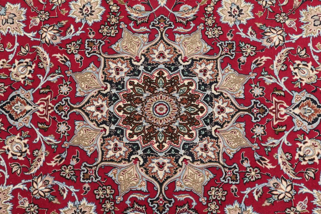 Handgeknoopt Isfahan-tapijt met een rood veld en verfijnd bloemmedaillon