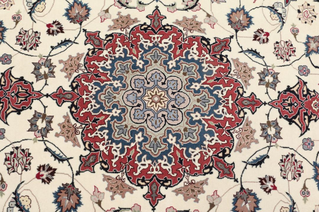 Un tapis Tabriz noué à la main provenant du Moyen-Orient avec un médaillon floral rouge sur fond crème.