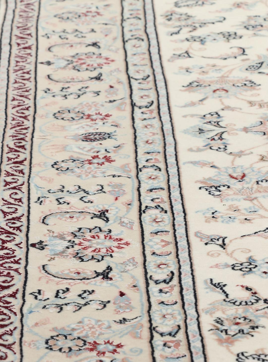 Et rektangulært håndknyttet Ilam Sherkat Farsh-tæppe med indviklede blomstermotiver i beige og bløde farver.