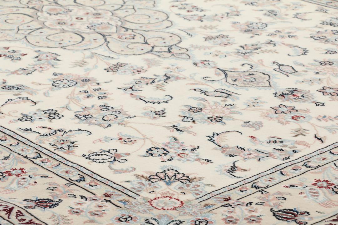 Et rektangulært håndknyttet Ilam Sherkat Farsh-tæppe med indviklede blomstermotiver i beige og bløde farver.