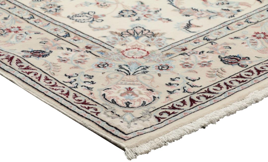 Et rektangulært håndknyttet Ilam Sherkat Farsh-tæppe med indviklede blomstermotiver i beige og bløde farver.