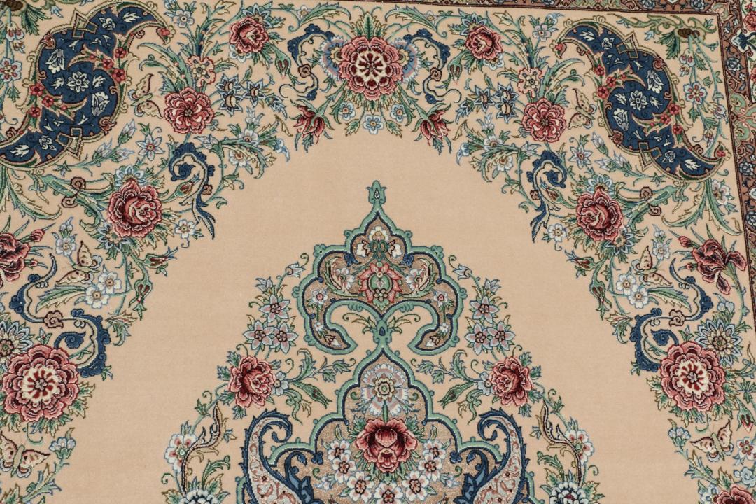 Et håndknyttet Isfahan-tæppe fra Mellemøsten i beige, blå og røde toner.