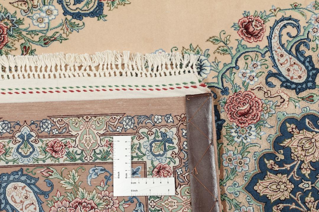 Et håndknyttet Isfahan-tæppe fra Mellemøsten i beige, blå og røde toner.