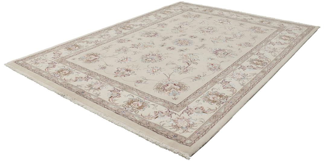 Et håndknyttet Tabriz-tæppe fra Mellemøsten i beige med indviklede blomstermønstre.