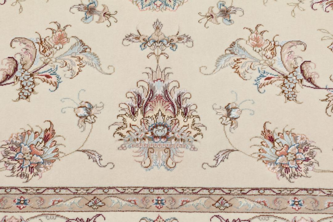 Et håndknyttet Tabriz-tæppe fra Mellemøsten i beige med indviklede blomstermønstre.