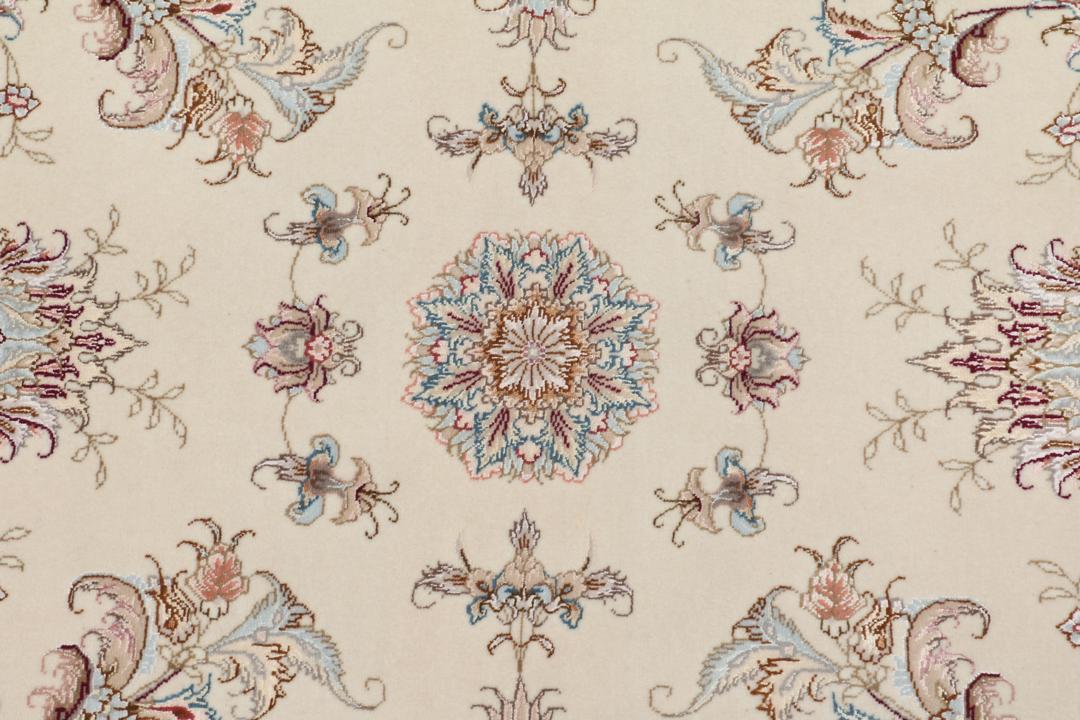 Et håndknyttet Tabriz-tæppe fra Mellemøsten i beige med indviklede blomstermønstre.