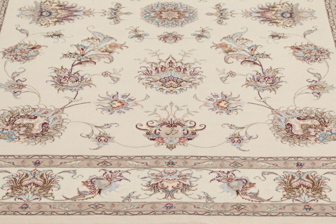 Et håndknyttet Tabriz-tæppe fra Mellemøsten i beige med indviklede blomstermønstre.