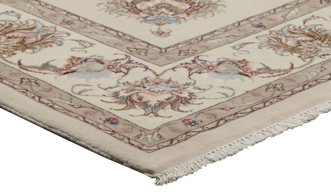 Et håndknyttet Tabriz-tæppe fra Mellemøsten i beige med indviklede blomstermønstre.
