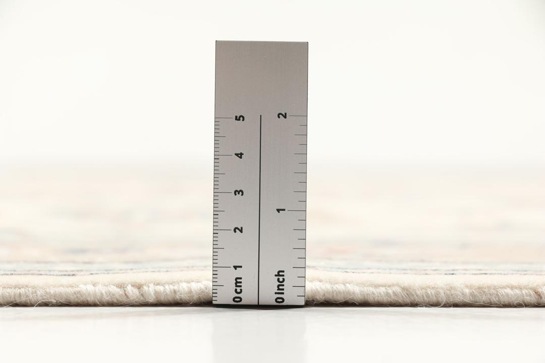 Beige Ilam Sherkat Farsh-tæppe med et blomstret medaljondesign